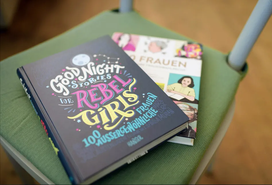 Auf einem Stuhl liegen zwei Bücher. Auf dem Titel des oberen Buches steht: Rebel-Girl.